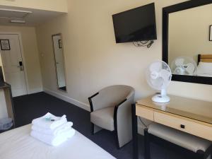 Una habitación de hotel con una cama, un escritorio y una silla. en Nysdill Hotel Norwich, en Norwich