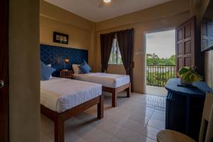 a hotel room with two beds and a balcony at Bayview Garden Resort in Tagbilaran City +77 photos