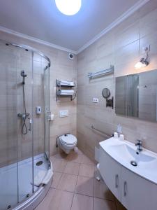 Un baño con ducha, inodoro y lavabo. en Camille Apartmanhouse, en Budapest 130 fotos más