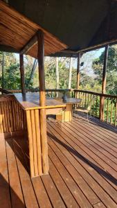 a wooden deck with a table and benches on it at Mpushini Falls Resort in Eshowe