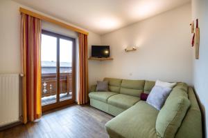 a living room with a couch and a large window at Ausserraingut in Flachau