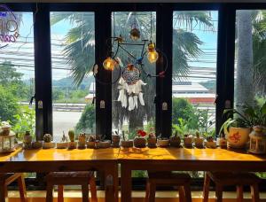 une table avec des plantes en pot devant une fenêtre dans l'établissement Home stay Ev Coffeehouse, à Ban Map Khao Wan