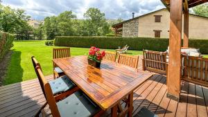 un tavolo in legno con un vaso di fiori su un ponte di La Maison du Fleuve a Ur