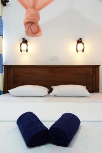 Guesthouse Kind and Love في هيكادوا: سرير عليه منشفتين زرقاوين