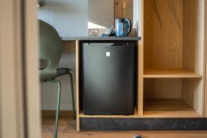 a small refrigerator in a cabinet with a chair at MyHotel Taastrup in Tåstrup