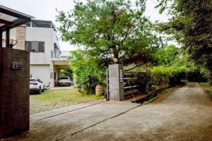 a house with a tree in front of a driveway at 山禾湖畔 in Xinshe