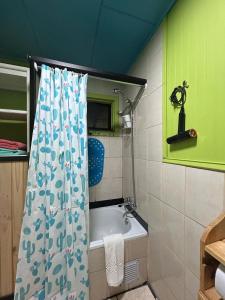 a bathroom with a shower curtain and a bath tub at Habitación Chilota in Castro