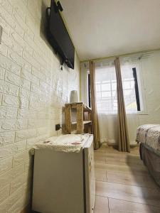 a room with a refrigerator and a brick wall at Habitación Chilota in Castro +27 photos