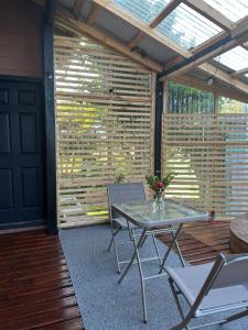 a screened in porch with a glass table and chairs at Habitación Chilota in Castro