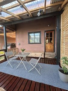 a patio with a table and chairs on a rug at Habitación Chilota in Castro