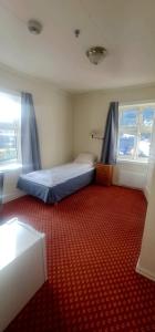 una camera con letto e tappeto rosso di Sauda Bed & Breakfast a Sauda