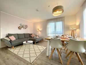 a living room with a couch and a table at Dresden Rooftop Apartment mit 2 Balkone, Stellplatz, Top Anbindung in Dresden