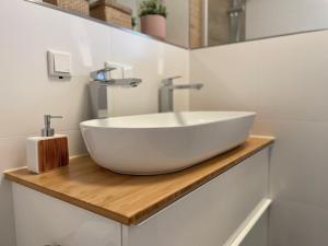 a bathroom with a white sink on a wooden counter at Apartment Rooftop - Dresden trifft Sächsische Schweiz! in Dresden +25 photos