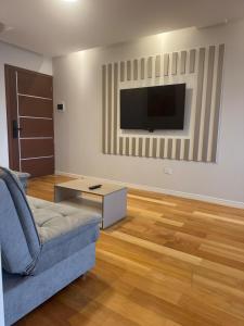 un salon avec un canapé et une télévision fixée au mur dans l'établissement Luxury and Relax at 8432 ft, à Cochabamba