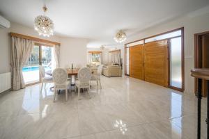 Blue Pearl Villa - 6 Bedroom في بيلا: غرفة طعام بها طاولة وكراسي