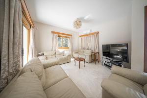 Blue Pearl Villa - 6 Bedroom في بيلا: غرفة معيشة مع أريكة وتلفزيون