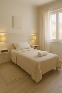 ミラマールにあるHotel Idealのベッドと窓のある白い寝室