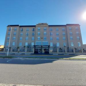 a large brown building with a street in front of it at El Aguila del Tuyu in San Clemente del Tuyú