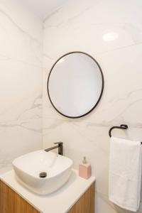 a bathroom with a white sink and a mirror at Kalamon Luxury Suite 105 w Pool & Gym in Livadhia +36 photos