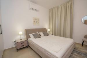 a bedroom with a bed and a table with two lamps at Kalamon Luxury Suite 105 w Pool & Gym in Livadhia