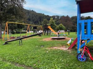 a playground with two swings and a slide at KNAUS Campingpark Nassau in Nassau