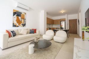 a living room with a couch and two chairs and a table at Kalamon Luxury Suite 105 w Pool & Gym in Livadhia