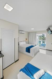 um quarto grande com 2 camas e uma janela em Pousada Oásis Tropical em Porto de Galinhas