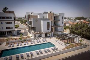 an aerial view of a building with a swimming pool at Kalamon Luxury Suite 105 w Pool & Gym in Livadhia