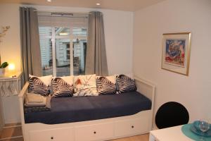 a bed with pillows on it in a room with a window at Skuteviksveien 42 in Bergen