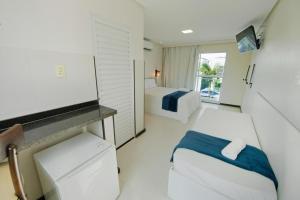 una camera con un letto e una TV di Pousada Oásis Tropical a Porto De Galinhas