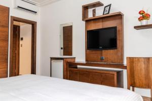 a hotel room with a bed and a flat screen tv at Britannia Suites in Beirut