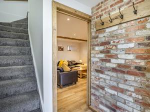 a brick wall in a living room with a staircase at The Hayloft-Uk34015 in Godshill +18 photos