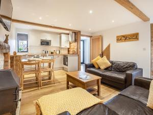 a living room with a couch and a kitchen at The Hayloft-Uk34015 in Godshill