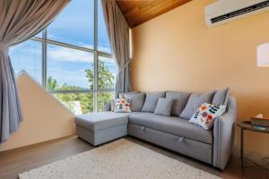 een woonkamer met een bank en een groot raam bij Luxury Villa - Pool - Gym - Steam Room - Garden in Ko Pha Ngan