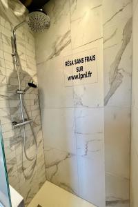 Gîte avec Terrasse et parking privé في Charnècles: حمام مع دش مع علامة على الحائط