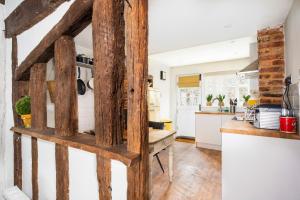 een keuken met witte muren en houten balken bij 3 Tudor Cottages in Long Melford