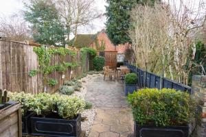 een tuin met potplanten en een houten hek bij 3 Tudor Cottages in Long Melford