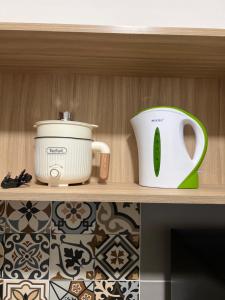 a shelf with a crock pot and a toaster at Homestay Kesidang in Seri Iskandar +2 photos