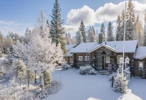 a log cabin in the snow with trees at Villa Talvikolo - Spacious 2BR Cabin with Sauna in Ruka