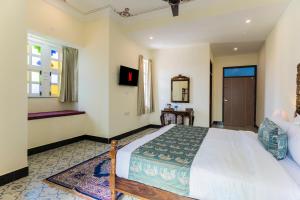 NāiAryavarta A Boutique Abode的一间卧室，配有一张大床和一扇窗户。