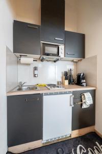 a small kitchen with a sink and a microwave at Quiet Studio - 2 Single Beds - Central - Netflix in Leoben