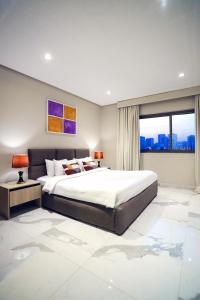 a bedroom with a large bed and a large window at Sea Loft Villas in Manama