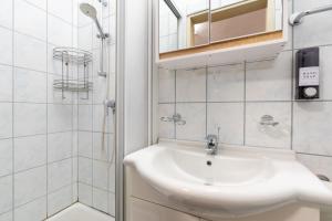 a white bathroom with a sink and a shower at Quiet Studio - 2 Single Beds - Central - Netflix in Leoben +11 photos