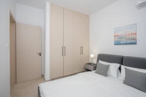 拉纳卡Kalamon Luxury Suite 202 w Pool and Gym的卧室配有白色的床和白色橱柜。 更多29张照片