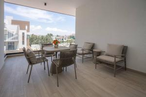 拉纳卡Kalamon Luxury Suite 202 w Pool and Gym的一间有桌椅和大窗户的餐厅