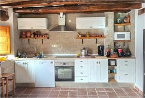 a kitchen with white cabinets and white appliances at Casa La Fuencisla in Castiltierra