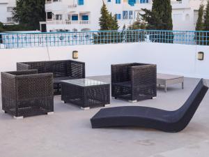 a group of wicker chairs and tables and a bench at Le Vert Panoramique S 03 in Sidi Bou Saïd