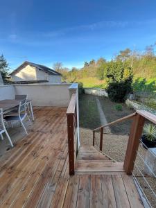 a wooden deck with a table and a bench at La maison du viaduc in Chauvigny