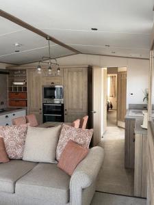 een woonkamer met een bank en een keuken bij Bishops Beach Stays in Walton-on-the-Naze