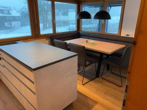 Haus Margret في ميلاو: مطبخ مع طاولة وكراسي ونوافذ